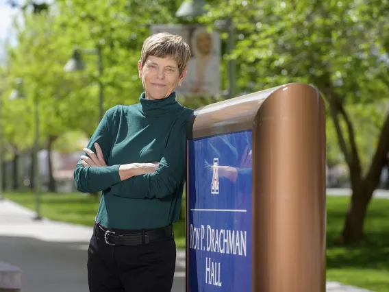 Woman leaning against a sign. 