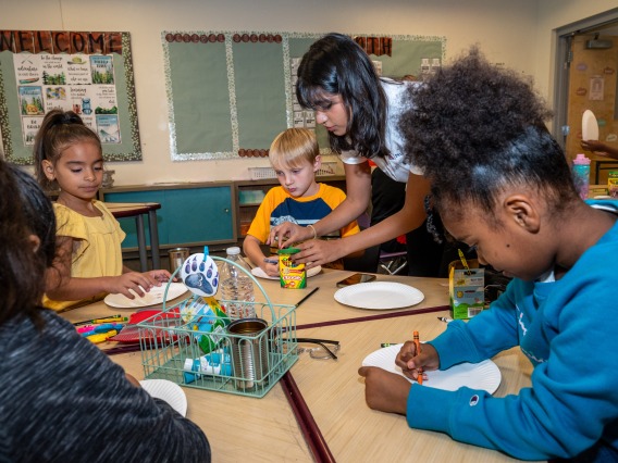 Pharmacy student guides young children through an health meal activity.