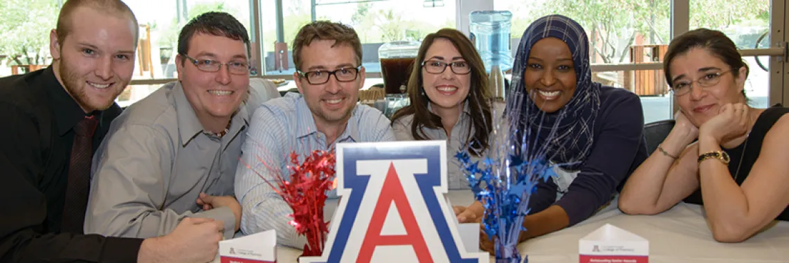A group of students around the UofA sign