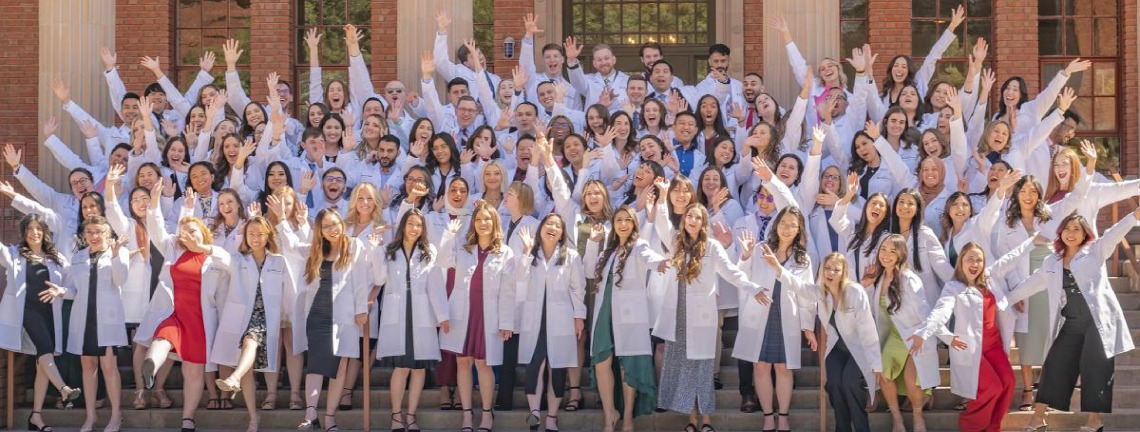 Large gathering of current students in white coats