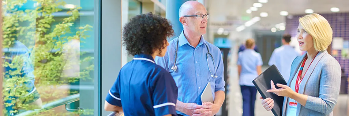 healthcare professionals talking to each other in the hallway