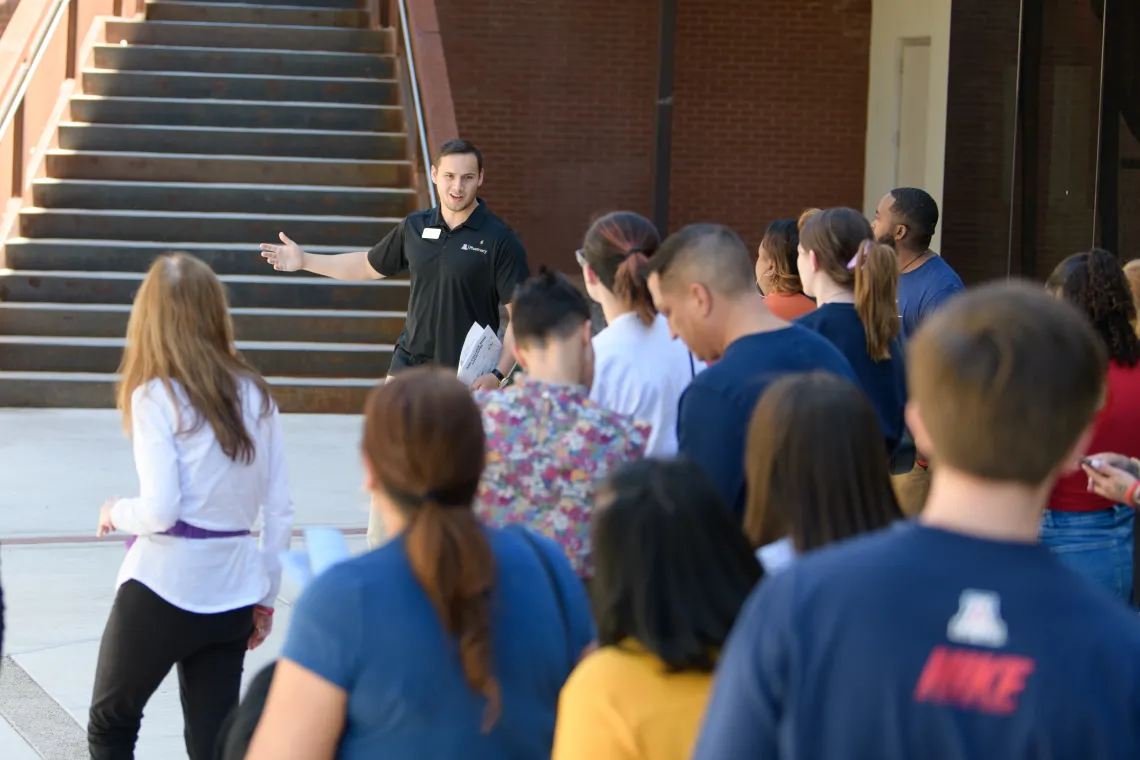 A student takes a group on a tour of the College of Pharmacy