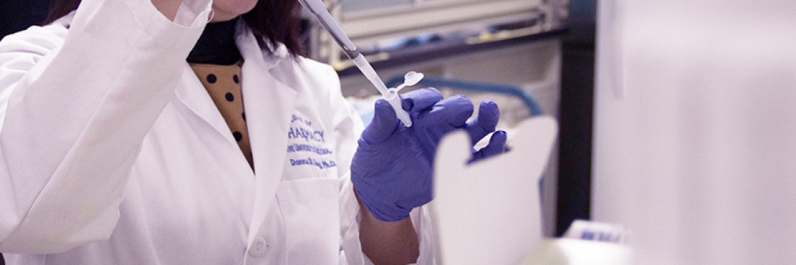 A researcher using a syringe. 