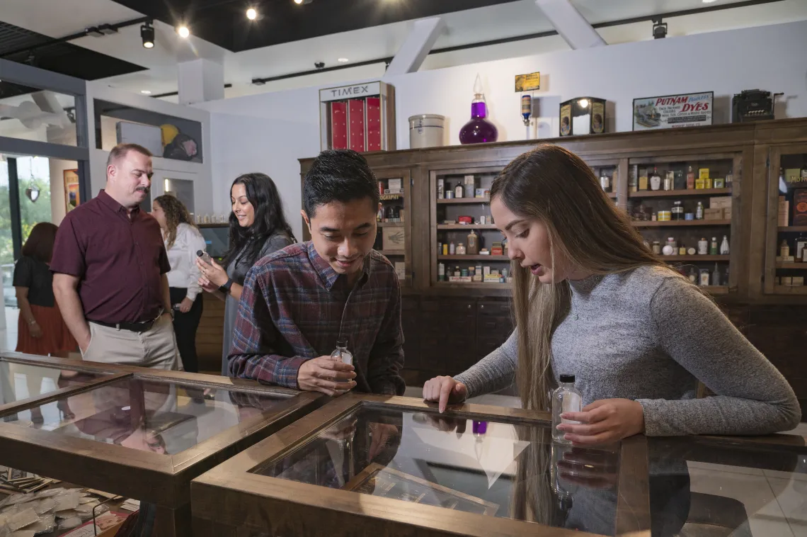 Students looking at pharmacy artifacts in the Coit Museum of Pharmacy & Health Sciences
