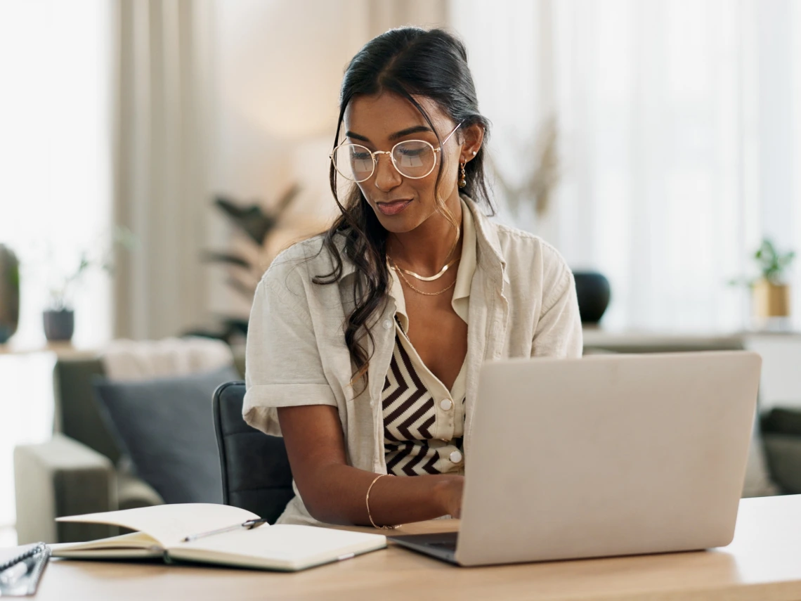 Student writes at laptop