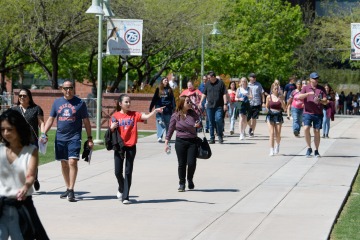Groups of people walking on the Tucson campus.