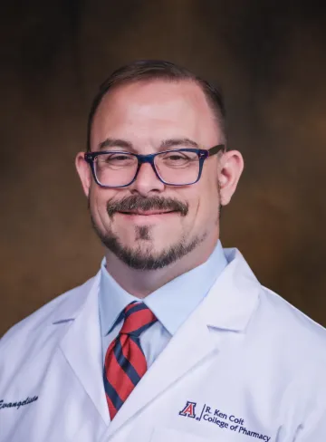 Ed Evangelista in a pharmacy white coat.