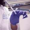 A researcher using a syringe. 