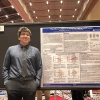 Alessandro Hernandez-De La Pena in front of a presentation poster.